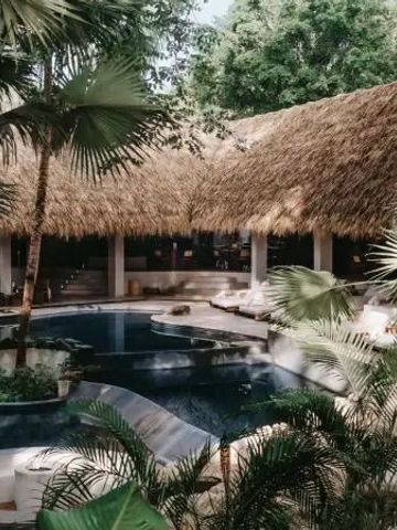Tropische Poollandschaft mit Strohdach