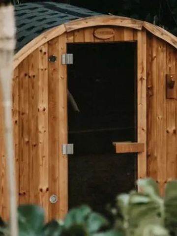 Runde hölzerne Sauna im Grünen