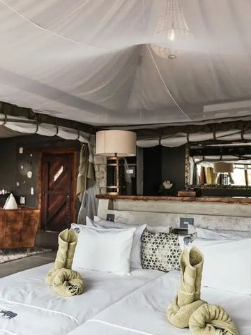 Luxuriöses Zimmer mit Moskitonetz, stilvollen Kissen und großzügigem Raum
