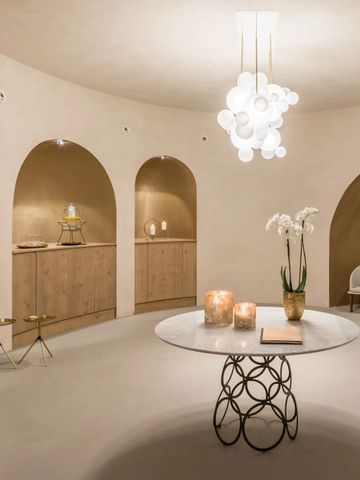 Eleganter, runder Raum mit Marmortisch und Designerlampe