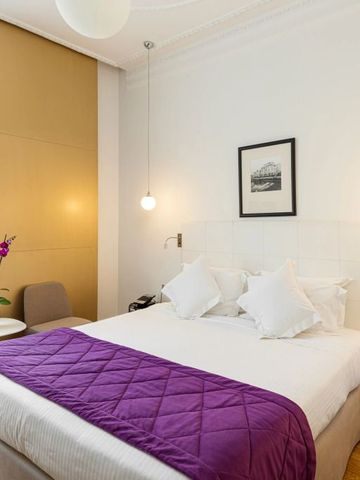 Elegantes Hotelzimmer mit modernem Design und lilafarbenem Akzent.