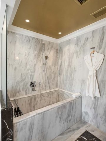 Luxuriöses Marmorbadezimmer mit eingelassener Badewanne.