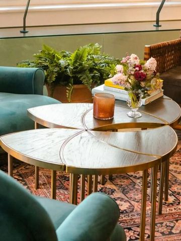 Eleganter Lounge-Bereich mit Sesseln, Couchtisch und Blumenarrangement im Hotel