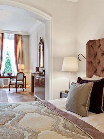 Luxuriöses Schlafzimmer mit gepolstertem Kopfteil und eleganter Dekoration