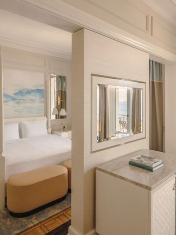Elegante Junior Suite mit künstlerischer Wandgestaltung und Seeblick
