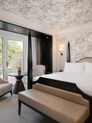 Helles Hotelzimmer mit eleganten Tapeten und Zugang zum Garten