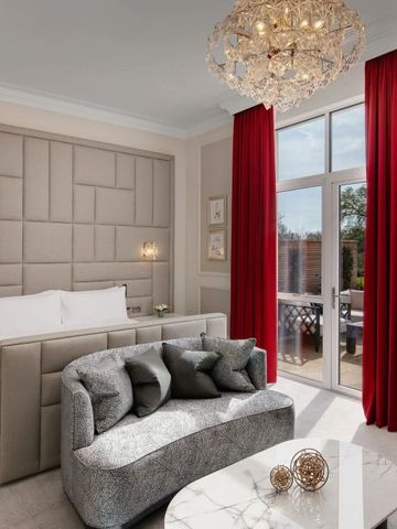 Elegantes Hotelzimmer mit Kronleuchter und rotem Vorhang