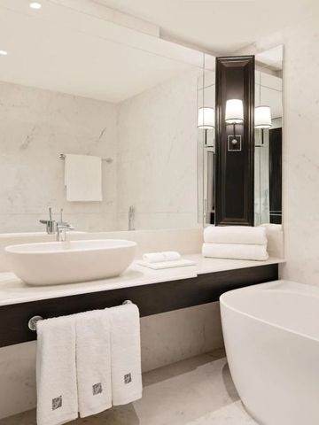 Helles Badezimmer mit freistehender Badewanne und eleganten Armaturen