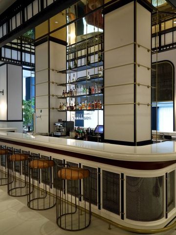 Elegante Hotelbar mit Hockern und Flaschenregal