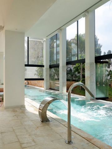 Indoor-Pool mit großen Fenstern und Gartenblick