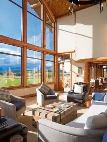 Große Lounge mit Panoramafenstern und stilvollen Sitzmöbeln mit Blick in die Natur
