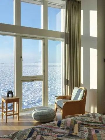 Zimmer mit großen Fenstern und atemberaubendem Blick auf die schneebedeckte Landschaft.