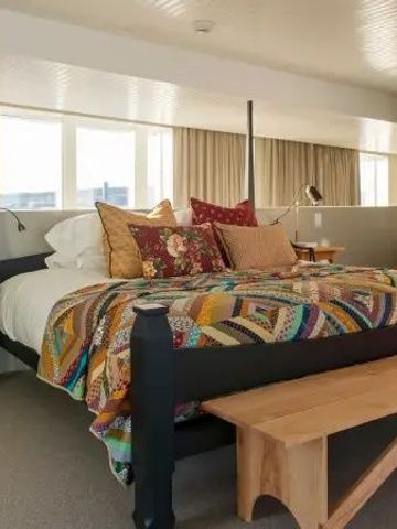 Gemütliches Schlafzimmer mit hoher Decke und dekorativem Bett.