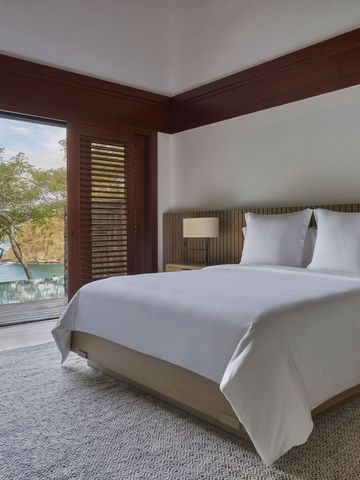 Helles Schlafzimmer mit Blick auf das Wasser und zeitgenössischer Einrichtung.