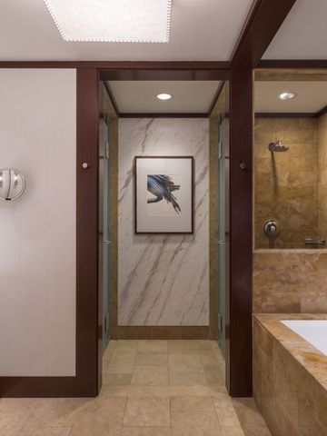 Modernes Badezimmer mit Marmorelementen und Kunstwerk an der Wand