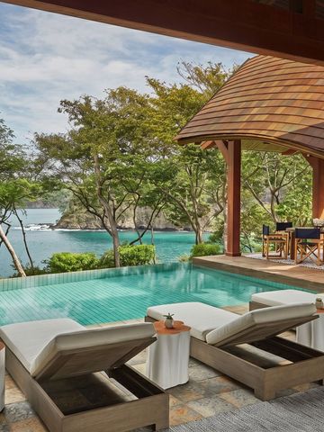 Private Terrasse mit Pool und Meerblick, umgeben von tropischen Bäumen