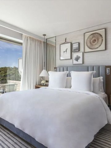 Elegantes Schlafzimmer im Four Seasons Astir Palace mit bequemem Doppelbett und Balkon
