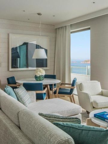 Großzügiger Wohnraum einer Hotel Suite mit gemütlicher Sofaecke und Meerblick