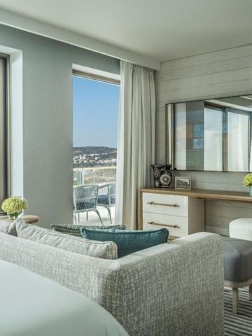 Modernes Schlafzimmer und Sitzecke in einer Suite mit Balkon und Meerblick.
