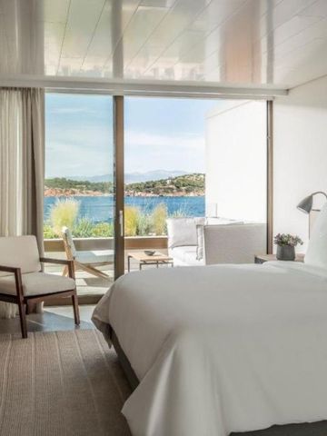 Elegantes Hotelzimmer mit Doppelbett, Panoramafenster und freiem Blick auf das Meer.