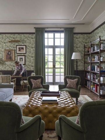 Gemütliche Lounge mit grünen Sesseln, Bücherschrank und Kamin im Four Seasons Hotel Hampshire