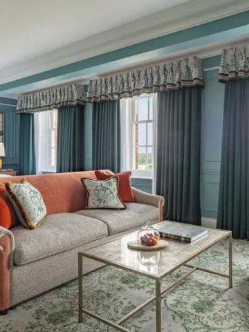 Luxuriöses Wohnzimmer einer Suite mit großen Fenstern und eleganter Dekoration