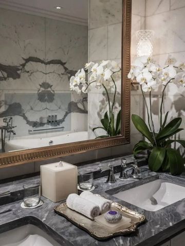 Luxuriöses Badezimmer mit Marmorverkleidung und elegantem Spiegel