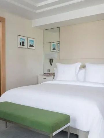 Helles Schlafzimmer mit Kingsize-Bett und moderner Einrichtung im Four Seasons Hotel
