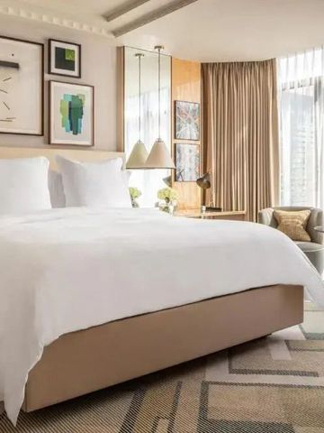 Modernes Hotelzimmer mit Kunstwerken an den Wänden und bodentiefen Fenstern.