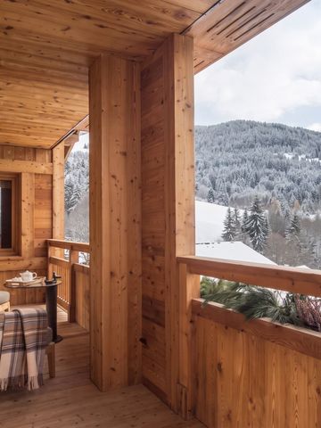 Holzveranda mit Sitzgelegenheit und Alpenblick