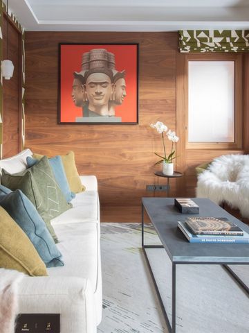 Modernes Wohnzimmer mit künstlerisch gestalteter Wand und bequemer Sitzecke.