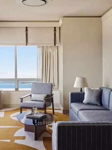 Gemütlicher Loungebereich im Hotelzimmer mit Fensterblick auf das Wasser