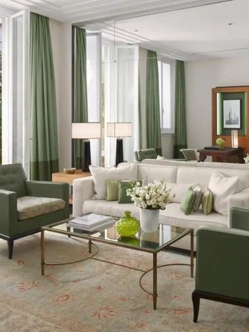 Luxuriöses Wohnzimmer mit weißen und grünen Akzenten, großen Fenstern und Zugang zur Terrasse