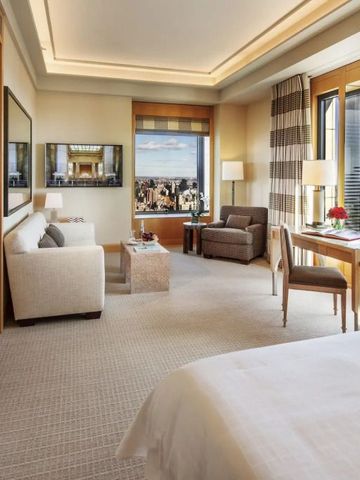 Hotelzimmer mit Stadtblick und komfortablen Sitzmöbeln