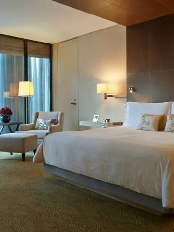 Elegant gestaltetes Schlafzimmer mit einem großen Bett und Stadtblick.