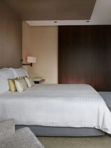 Helles Schlafzimmer mit King-Size-Bett in einem modernen Hotelzimmer.