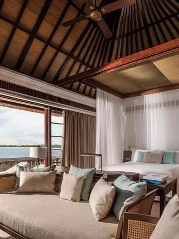Offenes Schlafzimmer einer Villa mit Blick auf das Meer und luxuriösem Interieur.