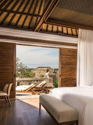 Helles Schlafzimmer einer Villa mit offenem Zugang zur Terrasse mit Meerblick.