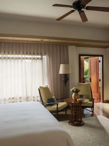 Helles Schlafzimmer mit Sitzbereich und direktem Zugang zum Garten