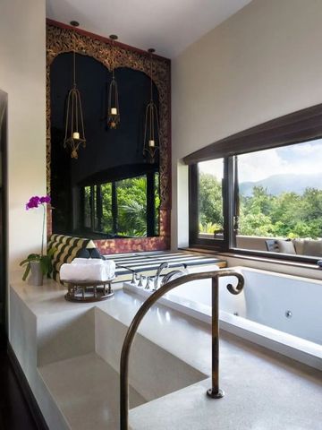 Helles Badezimmer mit großer Badewanne und Ausblick auf Natur
