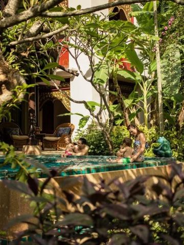Familie genießt einen privaten Pool im üppigen Garten