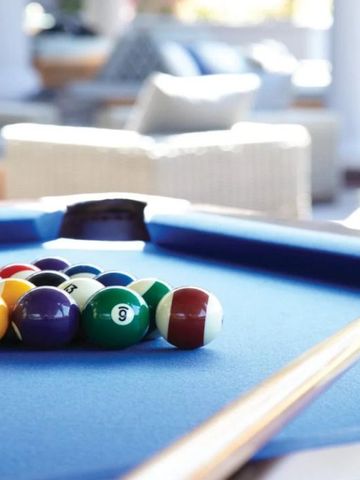 Billardtisch mit bunten Kugeln in heller, luxuriöser Lounge
