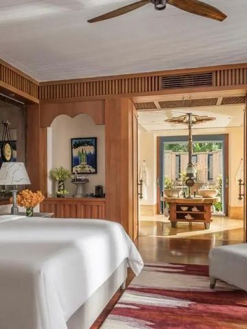 Elegantes Schlafzimmer in warmen Tönen mit moderner Kunst und verzierten Holzdetails