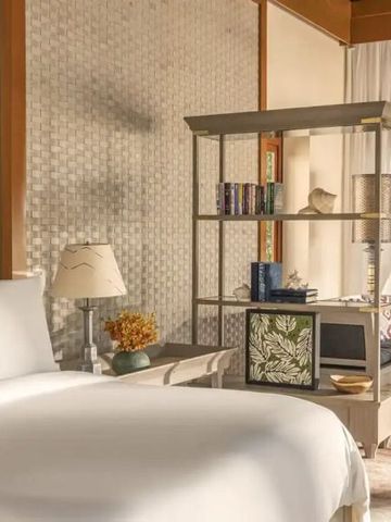 Helles Zimmer mit großem Bett und eleganter Dekoration mit Lichtdurchflutetem Loungebereich
