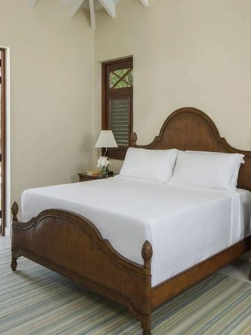 Elegantes Zimmer im Four Seasons Resort Nevis mit Holzdekor und komfortablem Bett.