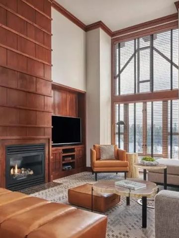 Geräumiges Wohnzimmer mit Kamin und großen Fenstern im Four Seasons Resort Whistler