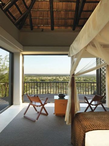 Zimmer mit Panoramafenstern und afrikanischem Dekor mit Blick auf die Natur