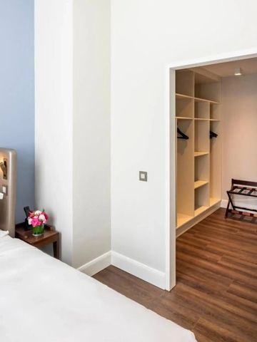 Blick auf das Schlafzimmer mit begehbarem Kleiderschrank im Fraser Suites Hamburg