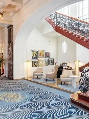 Elegante Hotel-Lobby mit kunstvollen Details und geschwungener Treppe