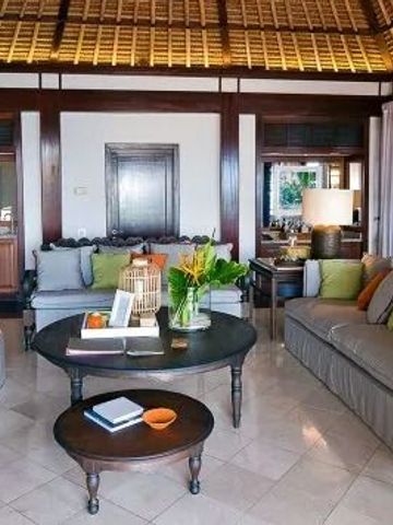 Luxuriöses Wohnzimmer einer Villa mit Holzmöbeln und reichlich Kissen